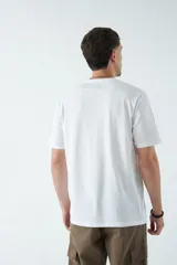 Remera azul marino de corte clásico con cuello redondo y manga corta. Estampado en el pecho con diseño geométrico en forma de triángulo que contiene una imagen de un atardecer.