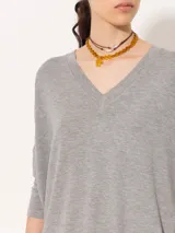 Remera negra de punto liviano con escote en V, mangas 3/4 y recortes diagonales en el delantero.