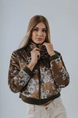 Campera bomber azul petróleo con estampado floral en tonos grises y blancos, cierre frontal y cuello alto.