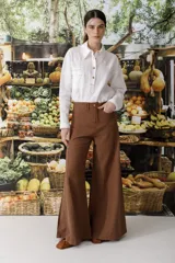 Pantalón de lino color crudo con finas rayas verticales negras, corte wide leg y tiro alto.