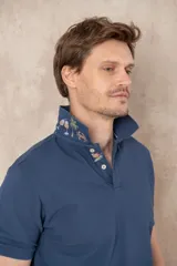 Remera tipo polo color beige, de manga corta y corte clásico. Tiene cuello con botones y está confeccionada en algodón.