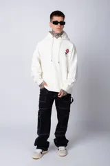 Buzo canguro negro de algodón friza, corte oversize y estampado de una rosa roja en el pecho.