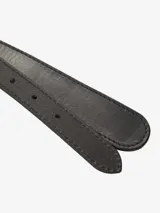 Cinturón de cuero negro con hebilla metálica grande de estilo rústico, con forma de letra 'C' o 'G' estilizada.