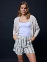 Cárdigan color beige tejido en hilado fino, con escote en V y cierre frontal con un botón.