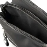 Bandolera negra de poliéster con correa regulable, cierre con cremallera y botón imantado. Tiene tres compartimentos, un bolsillo interno con cierre, un bolsillo interno abierto y un bolsillo externo con cierre.
