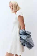 Vestido mini de manga corta en punto de algodón acanalado con pollera evasé. Modelo con cuerpo entallado y escote redondo amplio con ribete fino en color celeste y moña decorativa de satén. Ribete sobrehilado en mangas y bajo.