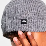 Gorro de lana gris de punto acanalado, con etiqueta con logo de The North Face en el frente.