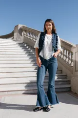 Pantalón de jean acampanado color marrón, con tiro alto, alforza central y ruedo desflecado.