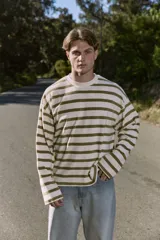 Buzo de manga larga color crudo con rayas horizontales color verde oliva, de corte oversize cropped y cuello redondo.