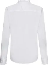 Camisa blanca de algodón orgánico con corte regular, cuello mao con volantes, cierre frontal con botones, mangas largas con puños abotonados y logo bordado en el ruedo.