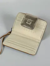 Billetera pequeña de cuero color marrón con cierre de cremallera y solapa dorada con broche a presión. Incluye correa de mano.