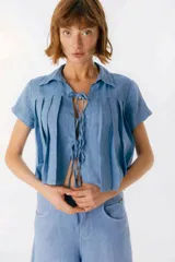Camisa celeste de lino con cuello clásico, mangas cortas, corte crop y lazos en el frente.