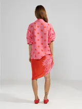 Camisa de manga 3/4 con puños elastizados, cuello camisero y estampado de figuras humanas y peces en color crema sobre fondo negro.