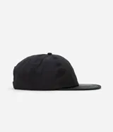 Gorra negra de poliamida con visera curva, protección UV e impermeable.