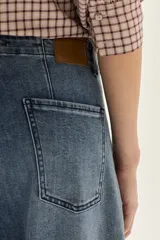 Jean de mujer, color azul medio lavado, tiro alto y corte ancho (wide leg).