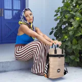 Matera estilo mochila color negro, confeccionada en nylon combinado con símil cuero. Cuenta con tapa con cierre metálico, bolsillo interno, asas y correa extensible.