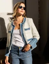 Chaqueta Nanette en tejido tweed color blanco y denim azul. Tiene cuello a la base, abertura central, bolsillos delanteros, puños con aplique de botones perlados, terminación desflecada y forro interno.