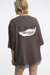 Remera blanca de algodón con cuello redondo y manga corta. Estampado pequeño de un ají rojo en el centro del pecho.