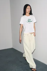 Camiseta blanca de algodón con cuello redondo y mangas cortas. Estampado frontal con la frase "Paris, Mon doux rêve!" en azul marino.