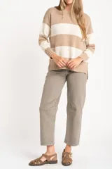 Sweater de punto con diseño de rayas horizontales anchas, alternando color beige camel y blanco roto con motas de color. Presenta cuello redondo y puños y borde inferior acanalados.