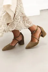 Zapato de tacón bajo color negro, con punta fina y tiras cruzadas sobre el empeine.