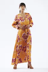 Vestido largo color naranja con estampado floral en tonos fucsia y blanco, escote en V y mangas largas.