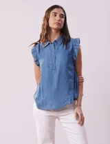 Blusa celeste de lyocell con cuello camisero, abertura con botones y volados en las sisas.