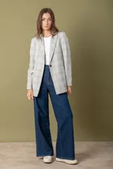 Blazer gris claro con estampado a cuadros en tonos beige, con solapas de muesca, cierre frontal con un botón y corte recto.