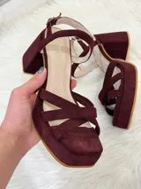 Sandalias de plataforma color vino con tiras cruzadas y tobillera con hebilla.
