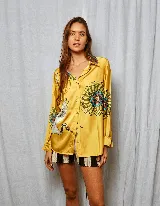 Camisa amarilla estampada con flores y grullas, de corte holgado, cuello solapa y manga larga.