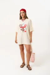 Remerón de algodón color crema con estampado de motivos marinos en tonos rojo y celeste, de corte oversize y largo a la rodilla.