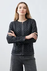 Chaqueta negra de cuero sintético con diseño acolchado en forma de espiga y detalles de tul.