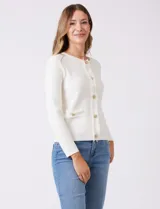 Cardigan tejido color fucsia, con escote a la base y abertura central con botones metálicos dorados. Presenta bolsillos simulados en la parte delantera y terminación desflecada en la abertura y los bolsillos.