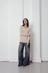 Sweater color beige de tejido suave y ligero, con cuello redondo y mangas largas.