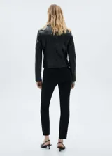 Pantalón negro de corte skinny, tiro medio y largo a la altura del tobillo.