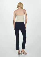 Pantalón cigarette negro con corte a la altura del tobillo y aberturas laterales.
