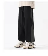 Pantalón deportivo negro con tobillos ajustables y forro polar interior.