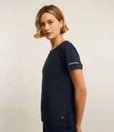 Remera deportiva blanca texturizada, con cuello redondo, manga corta, detalle reflectante y pliegue en la espalda.
