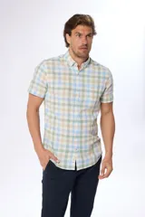 Camisa de manga corta con estampado a cuadros en tonos verde, beige y celeste. Modelo slim fit con bolsillo en el pecho.