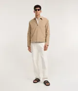 Campera masculina color marrón confeccionada en sarga, con cuello inglés, cierre de cremallera frontal, manga larga y bolsillos con detalles.