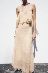 Vestido midi color crema de punto pointelle con tirantes finos y volantes en el escote.