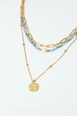 Set de collares en acero inoxidable, con detalles en perlas y cadenas de diferentes largos.