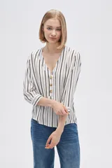 Camisa holgada de viscosa con estampado de rayas verticales en blanco y negro, cuello en V y mangas 3/4 con detalle de botones.