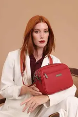 Bandolera color mostaza de simil cuero, con tres cierres principales, cierre delantero y bolsillo trasero. Incluye correa ajustable.