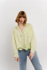 Camisa color crema de manga larga con cuello camisero y detalles de encaje en el escote. Se ata en la parte delantera.