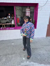 Campera corta con estampado a cuadros en tonos azul, rojo y blanco. Tiene cuello clásico, cierre con botones a presión y bolsillos laterales.
