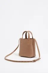 Bolso mini de piel vacuna color negro, con estructura blanda y formato vertical. Tiene doble asa corta, correa larga regulable, cierre con cinta, logo metálico BIMBA Y LOLA, acabados metálicos, bolsillo interior con cierre de cremallera e interior con logo grabado.