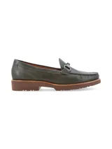 Mocasín de cuero negro con detalle de hebilla metálica plateada.