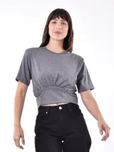 Remera corta color blanco hueso, con cuello redondo y frunce elástico en la cintura.