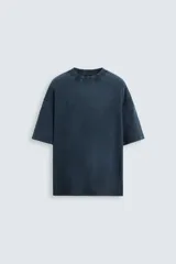 Camiseta azul marino de corte holgado, confeccionada en algodón con cuello redondo y mangas cortas. Presenta un efecto de lavado que le da una apariencia única.